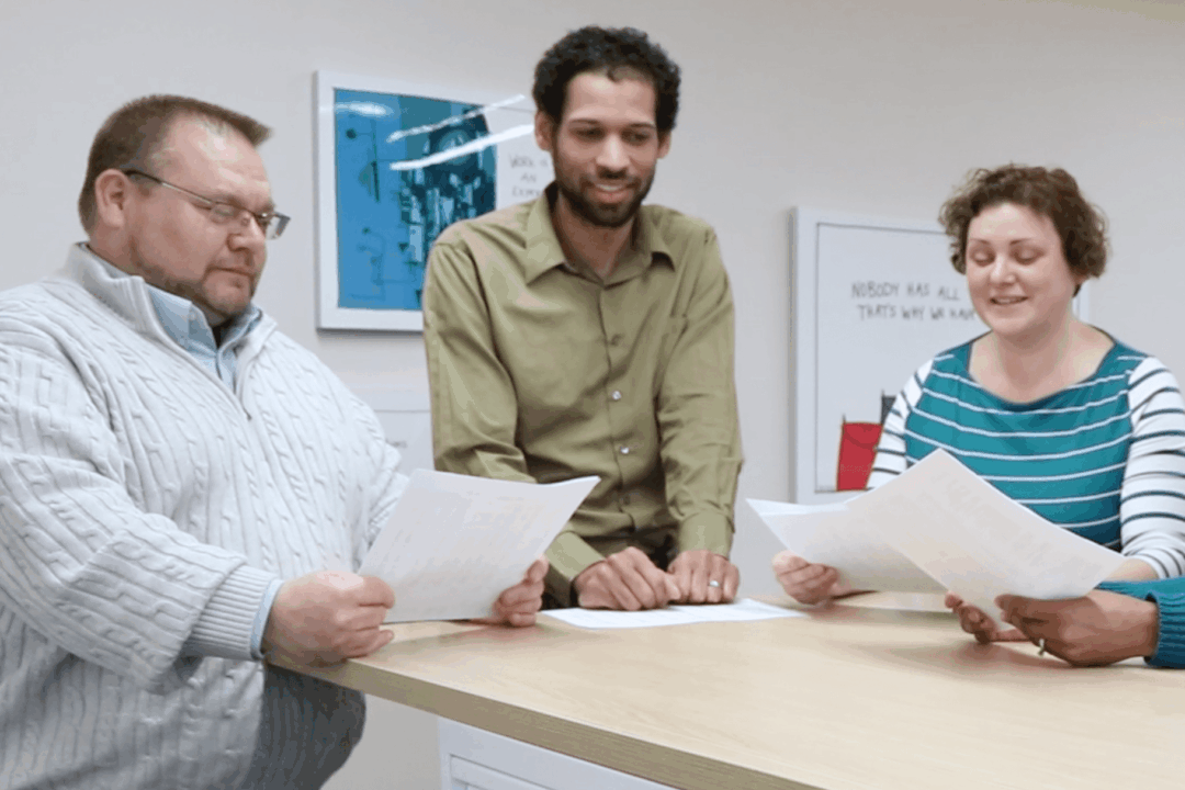 Three Hajoca employees standing at a table reviewing documents