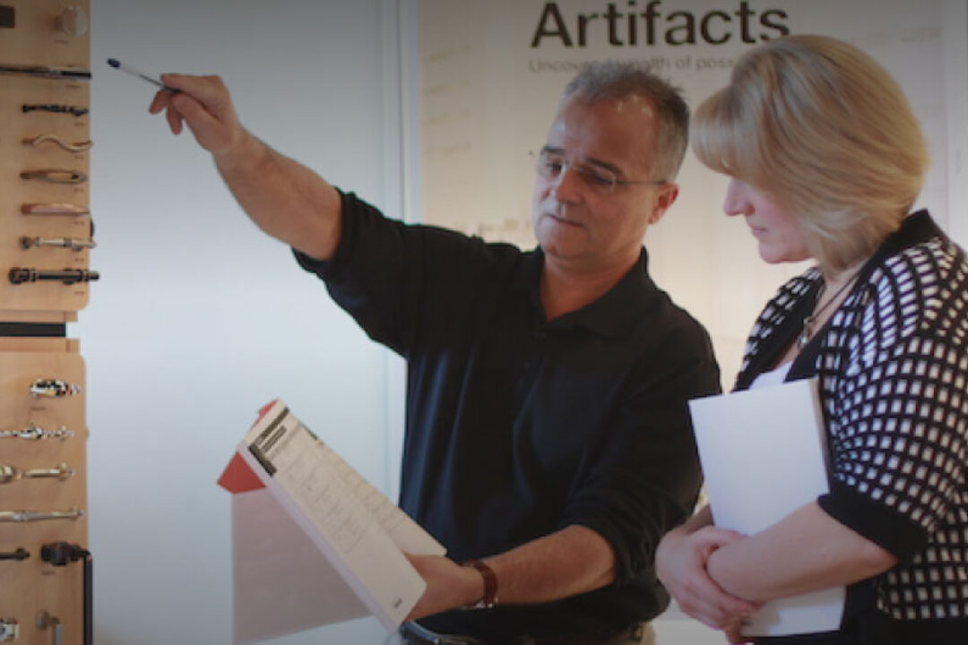 Man working in a showroom and helping a woman find a handle for her bathroom.