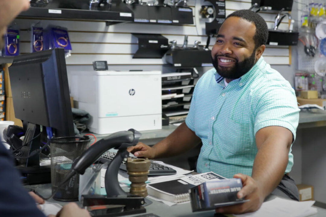 Smiling Hajoca teammate working the register at a sales counter